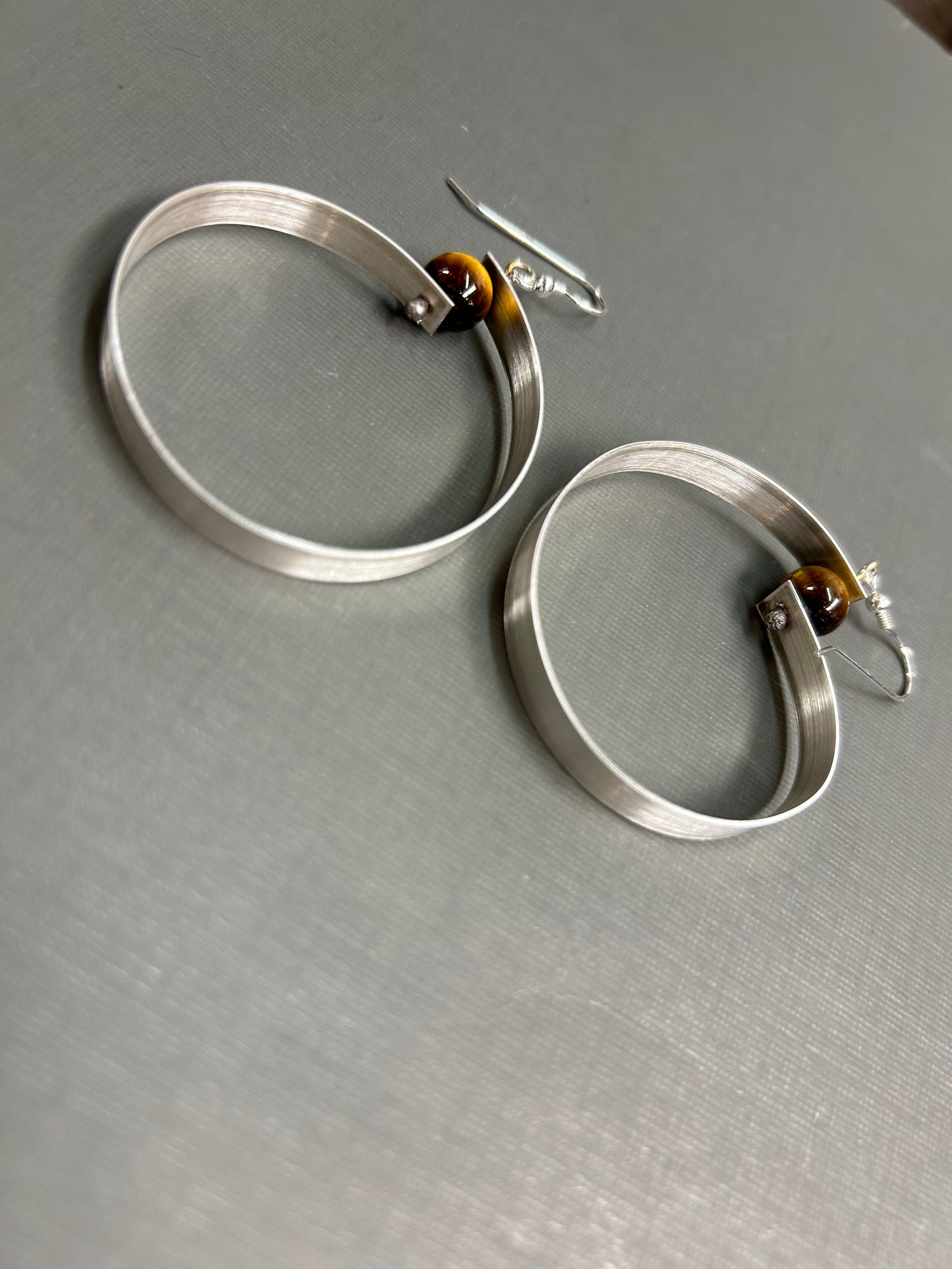Wide silver hoops and gemstone earrings